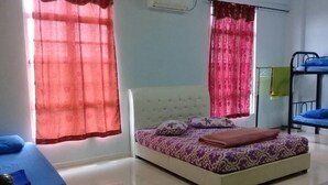 A bedroom with a bed, a bunk bed, and a bedside table.