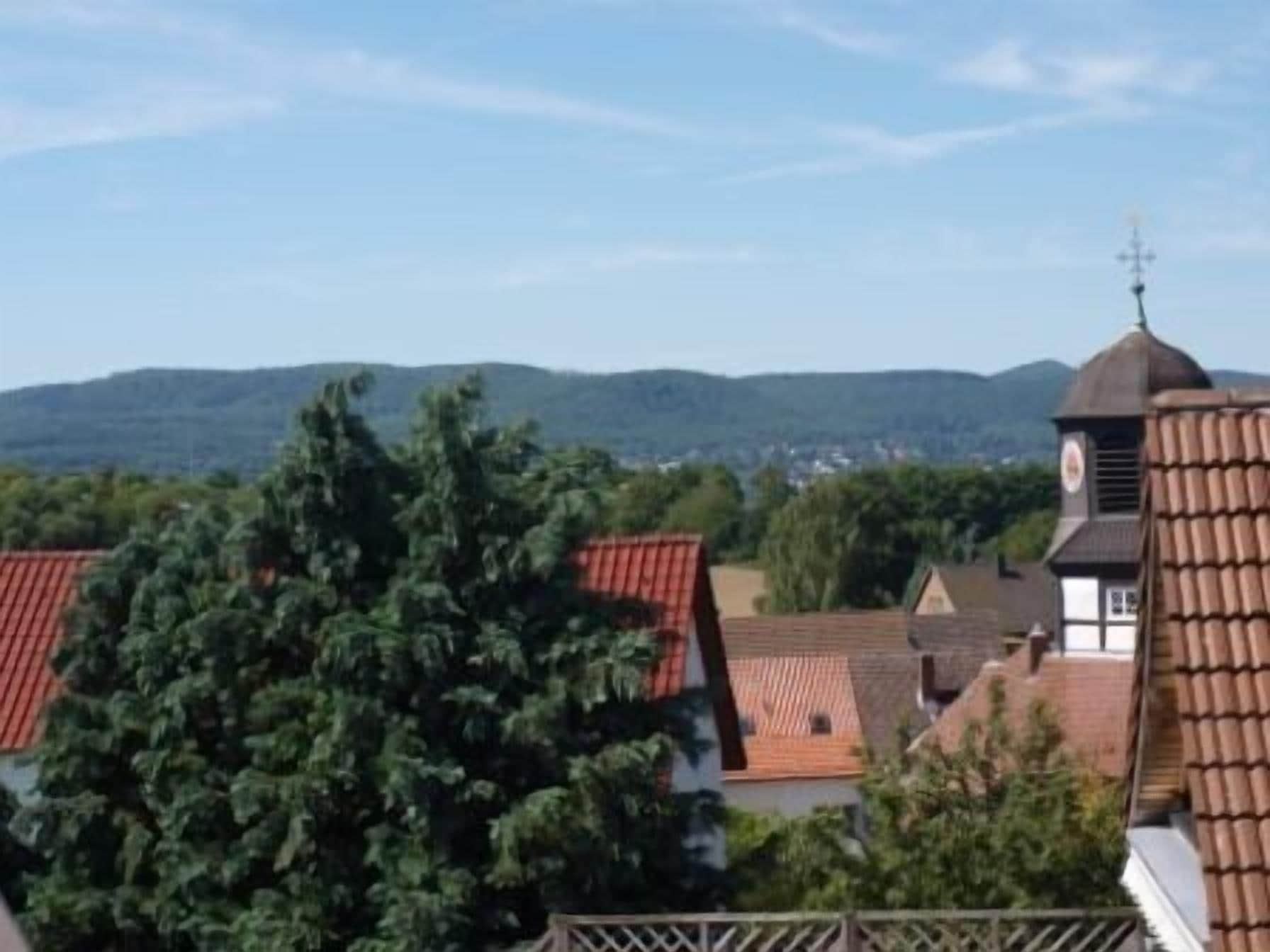 A village with traditional architecture, including a church with a clock tower and red-tiled roofs.