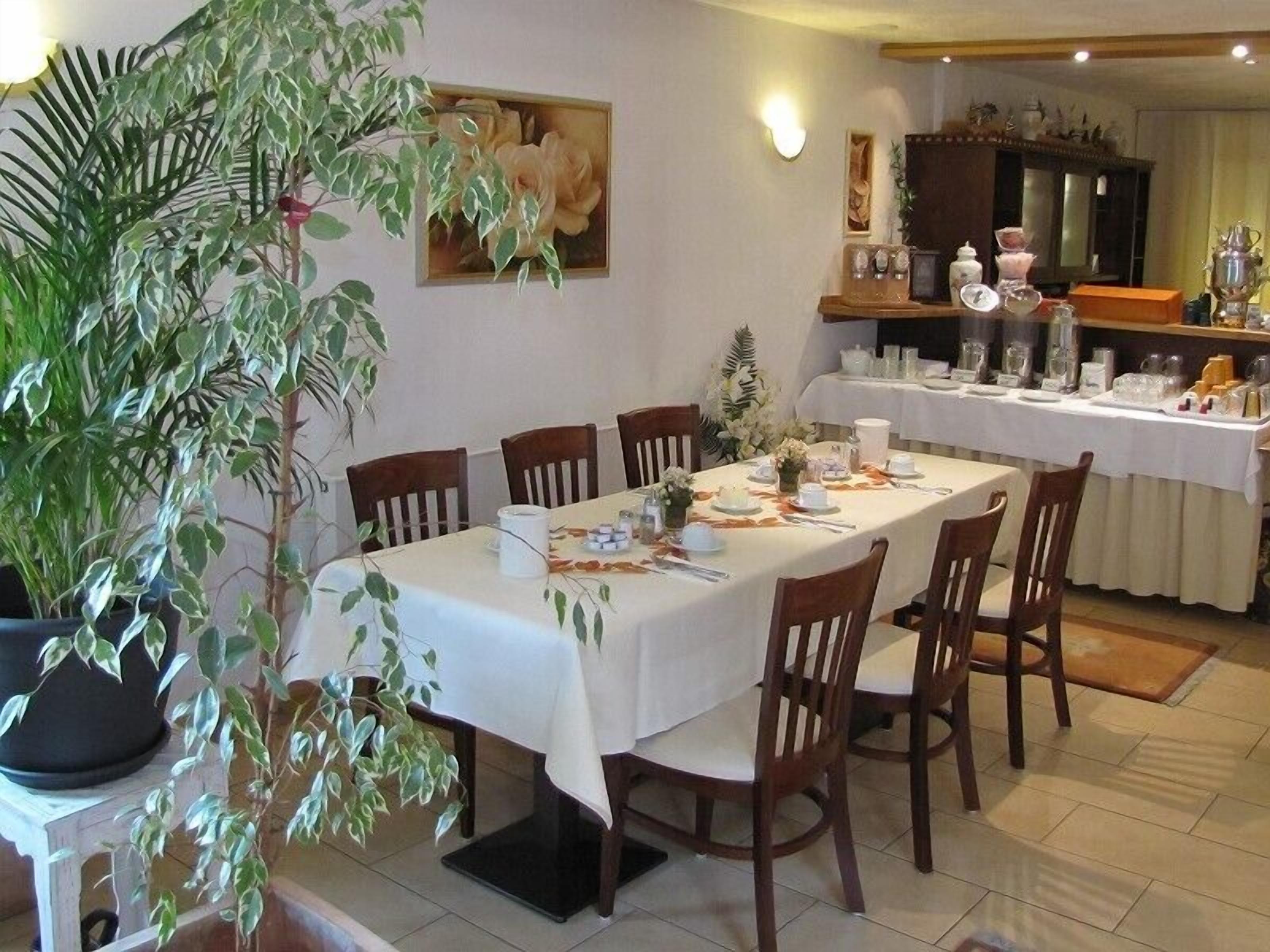 Comedor con una mesa larga dispuesta para seis personas, rodeada de sillas de madera.