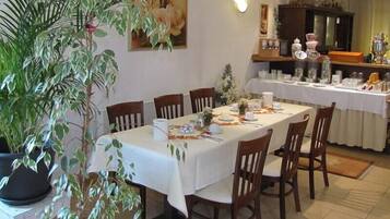Comedor con una mesa larga dispuesta para seis personas, rodeada de sillas de madera.