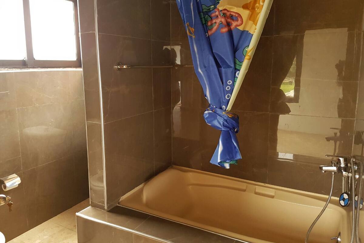 Un baño con bañera, cortina de ducha y retrete.