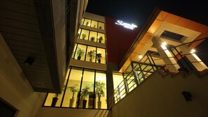 A multi-story building with a prominent sign that reads "Sofitel." The building features large windows on the upper floors, allowing natural light to enter. - Suave Hotel (Seogwipo)