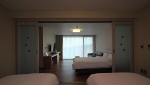 A hotel room with two beds, a desk, a chair, and a television. - Suave Hotel (Seogwipo)