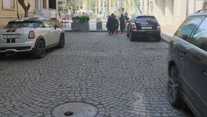 A cobblestone street with parked cars and pedestrians. - Fountain Square Hotel (Baku)