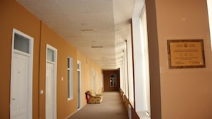 A hotel corridor with doors, a fire extinguisher, and a plaque on the wall. - Fountain Square Hotel (Baku)