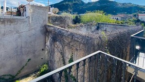 A rooftop with satellite dishes, a metal railing, and a view of a mountainous landscape. - Mamamia Guesthouse (Lipari)