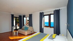 Ein Hotelzimmer mit einem großen Bett, einer Couch und Meerblick.