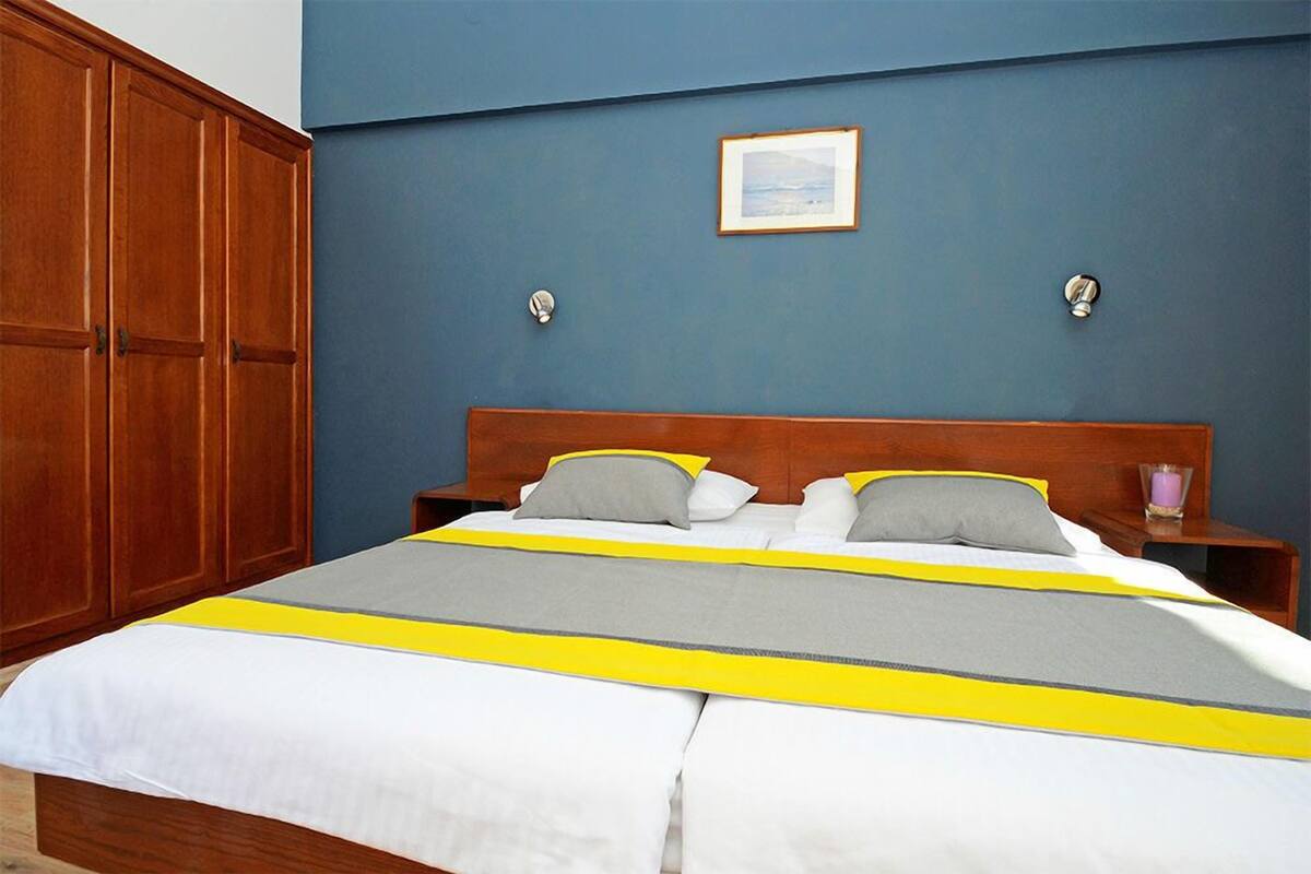 Un dormitorio con una cama grande, un armario de madera y un cuadro enmarcado en la pared.