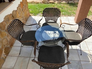 A patio with a glass-top table surrounded by wicker chairs. - Complejo Rural Ibipozo (Pozo Alcon)