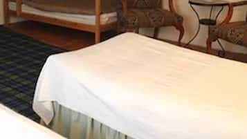 A room with a bed, a chair, and a small table.