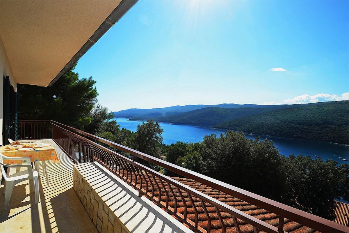 Ein Balkon mit Blick auf einen See und Berge.