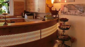 Un área de recepción con mostrador de madera, lámparas colgantes y una escultura de ciervo.