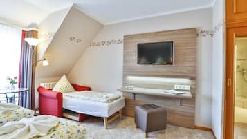 A modern bedroom with a bed, a desk, a TV, and a bathroom door.