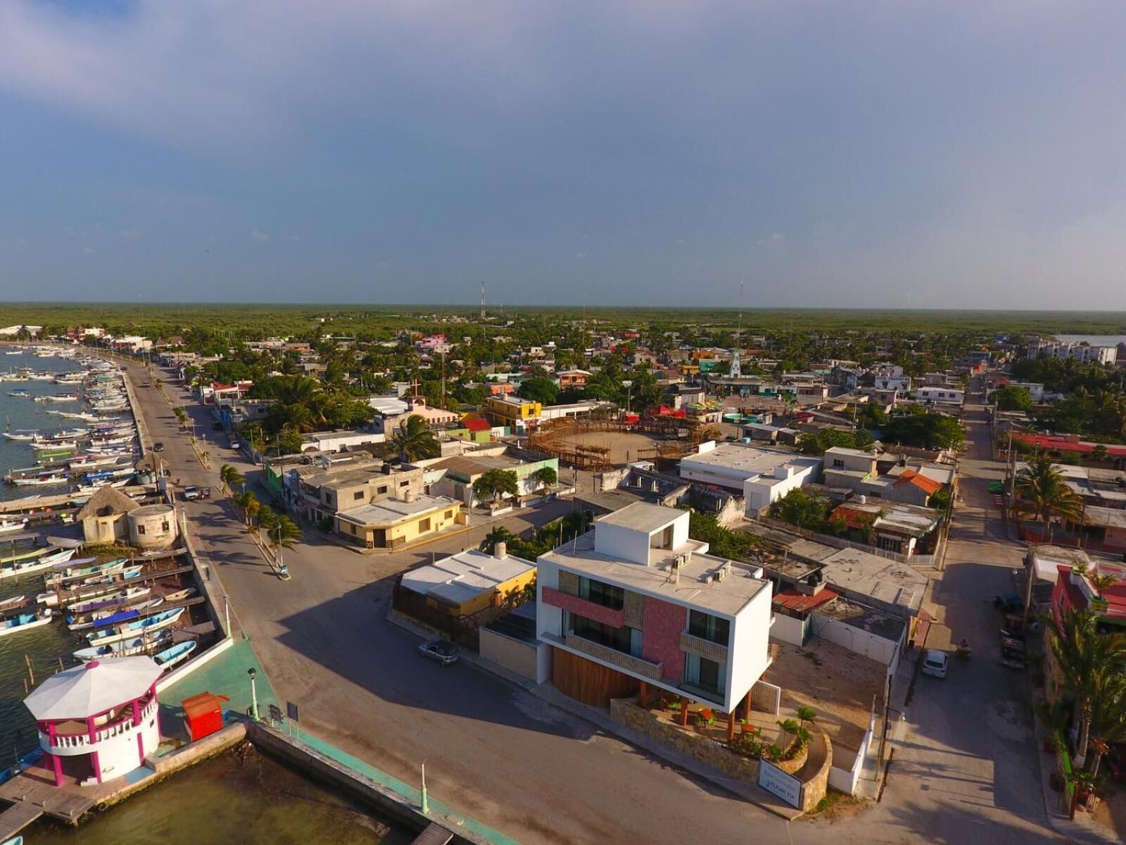 A coastal town with a marina, modern buildings, and a mix of residential and commercial structures.