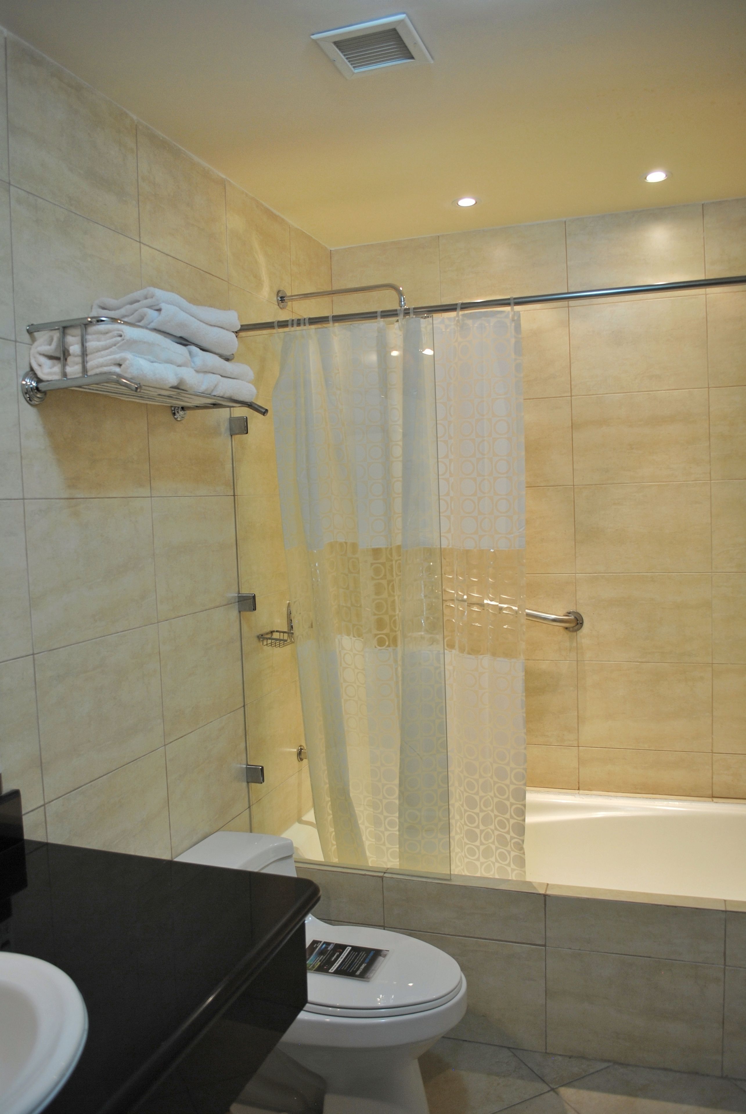 A modern bathroom with a bathtub, toilet, and a shower area with a glass door.