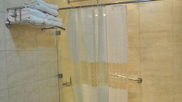 A modern bathroom with a bathtub, toilet, and a shower area with a glass door.