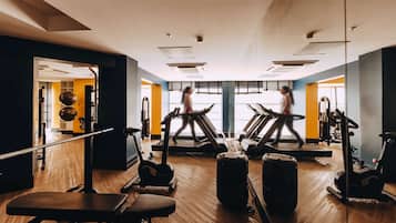 A gym with treadmills, exercise bikes, and weights.