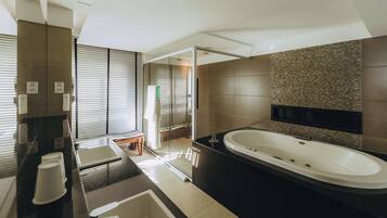 Une salle de bain moderne dotée d’une grande baignoire, d’une douche séparée et d’un meuble-lavabo avec un miroir.