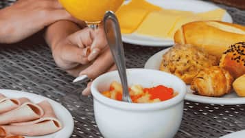 Una comida con diversos platos, incluyendo un vaso de jugo de naranja, pan y un bol de comida.