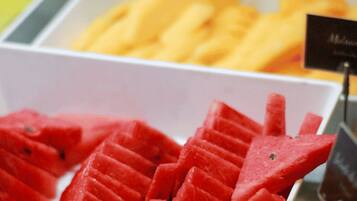Exposição de frutas fatiadas em uma seção refrigerada de uma loja.