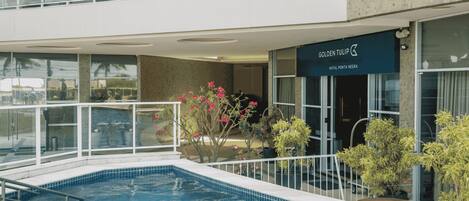 Un hotel con piscina, un balcón con vistas y un cartel que dice 'GOLDEN TULIP'.
