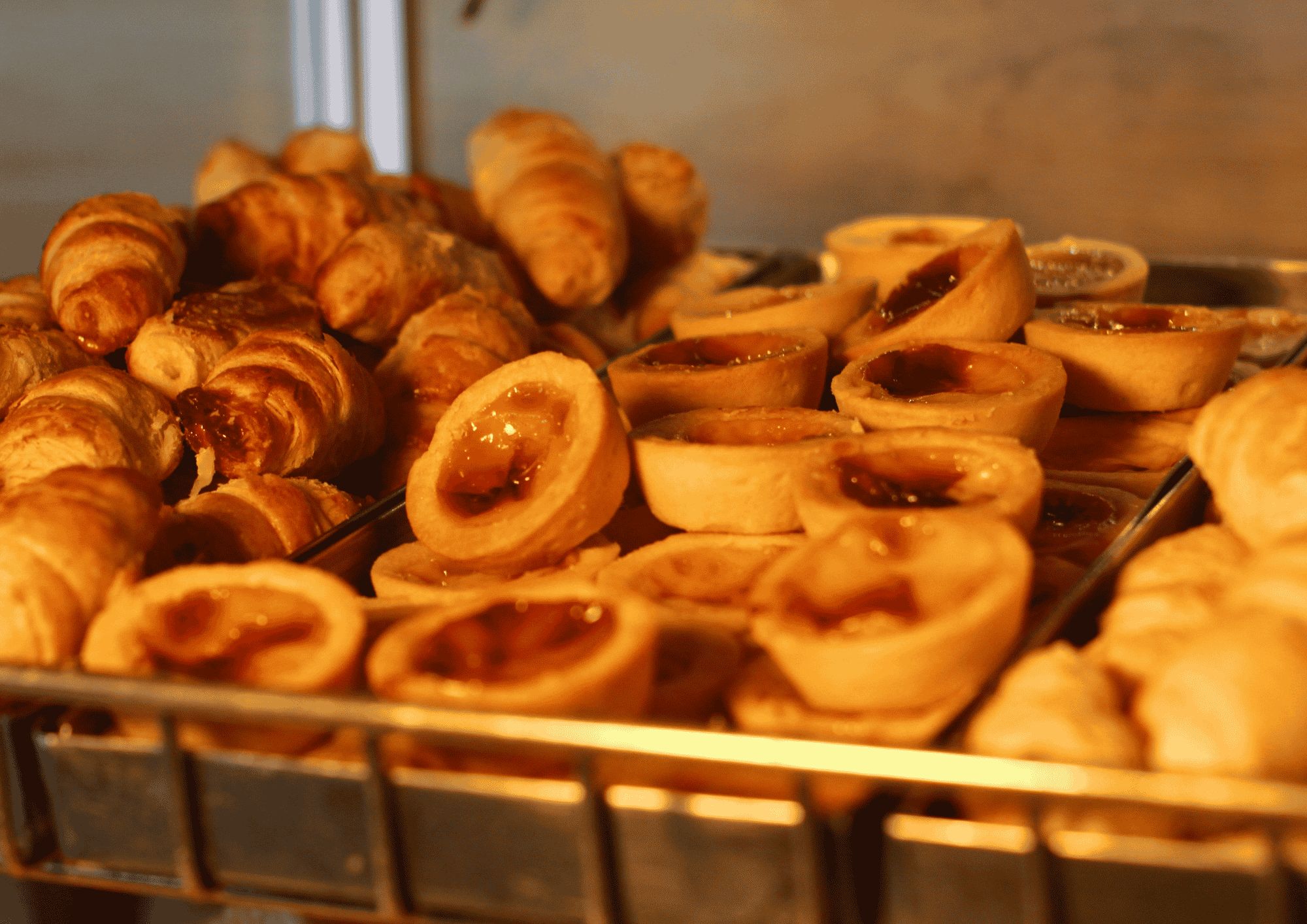 Una bandeja de productos horneados, incluyendo croissants y tartaletas.