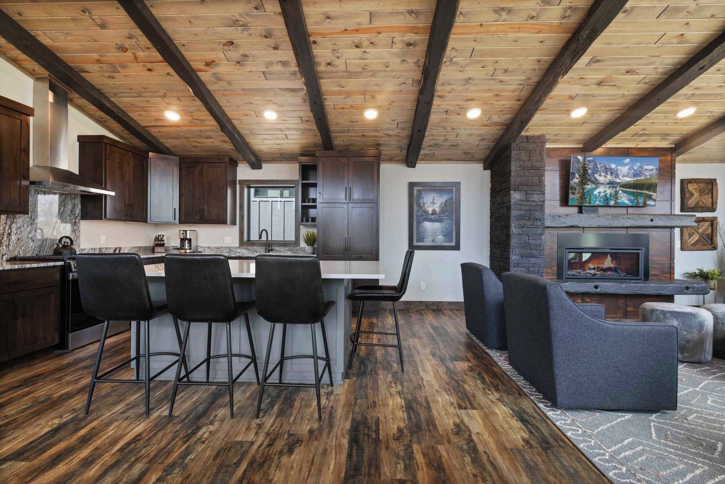 Una cocina moderna con armarios de madera oscura, encimera de mármol y una isla central con taburetes de bar.