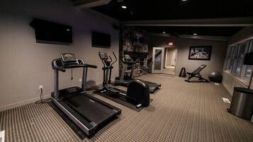 A gym with treadmills, elliptical machines, and exercise balls.