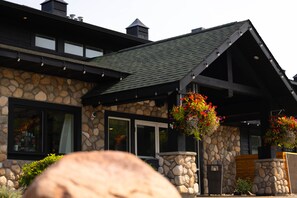 A stone building with a dark roof and large windows.