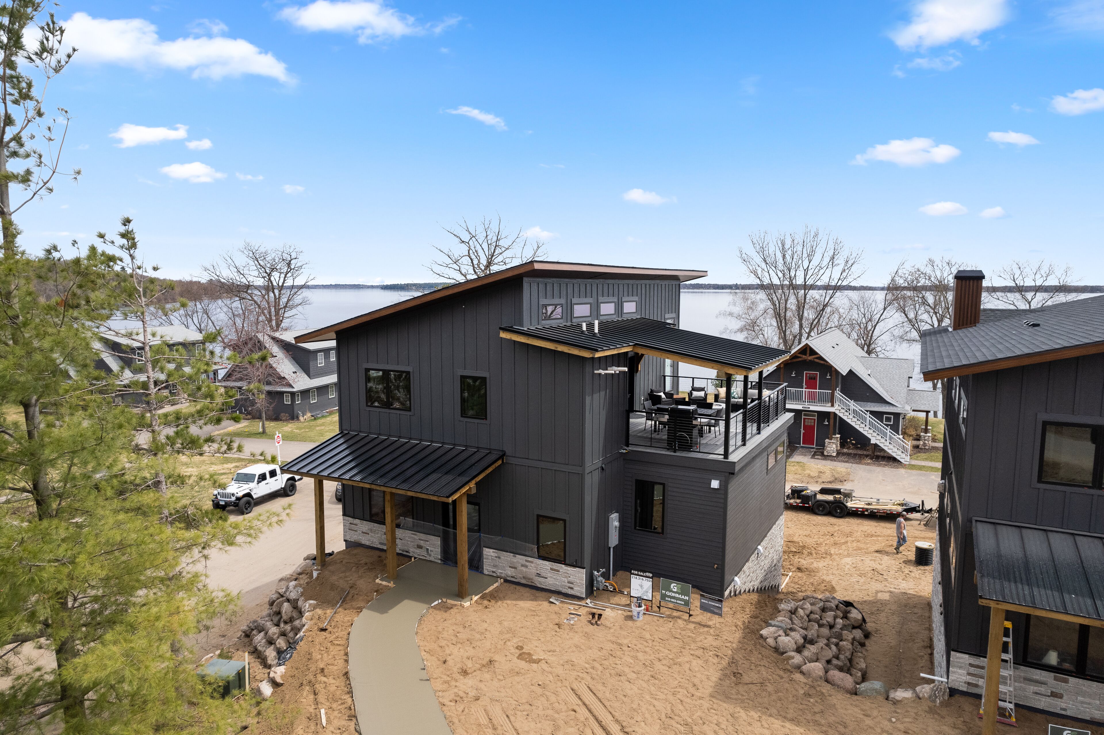 A modern two-story house with a balcony and a covered patio area.