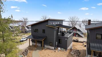 A modern two-story house with a balcony and a covered patio area.