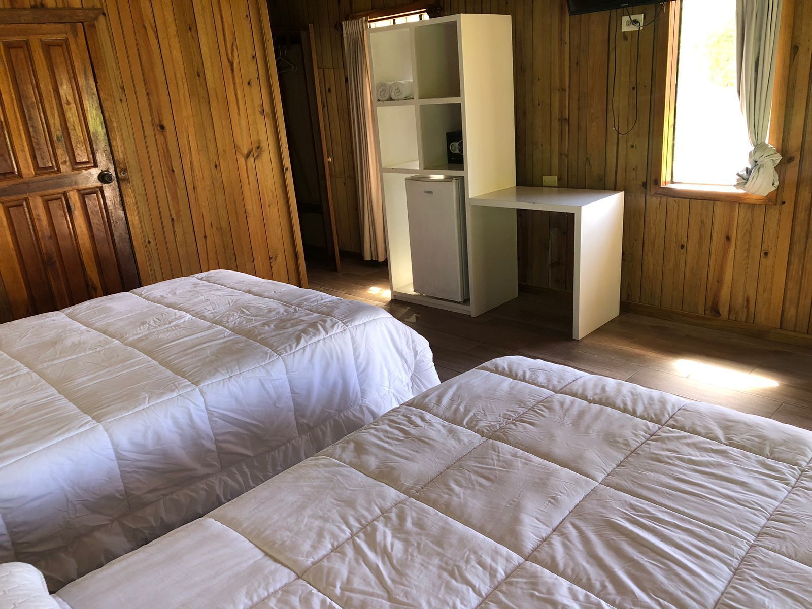 Een kamer met twee bedden, een bureau en een kledingkast.