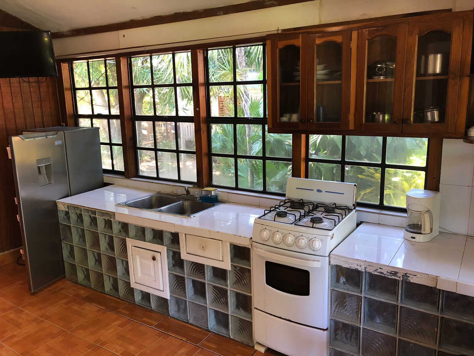 Una cocina equipada con refrigerador, lavaplatos, estufa y gabinetes.