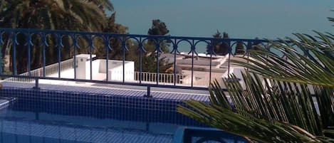 Una piscina al aire libre, sillones reclinables de piscina