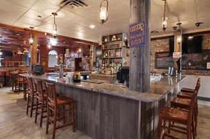 A bar area with wooden bar stools, a granite countertop, and a sign indicating the bar offers mineral water.