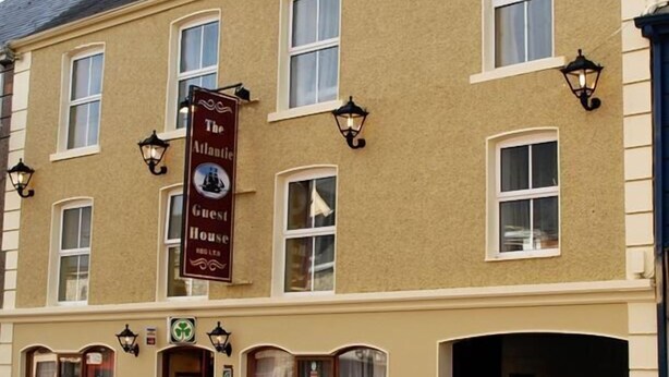 Un edificio de dos pisos con un letrero que dice 'The Albion Guest House'.