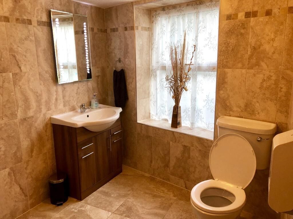 A bathroom with a sink, mirror, and toilet.