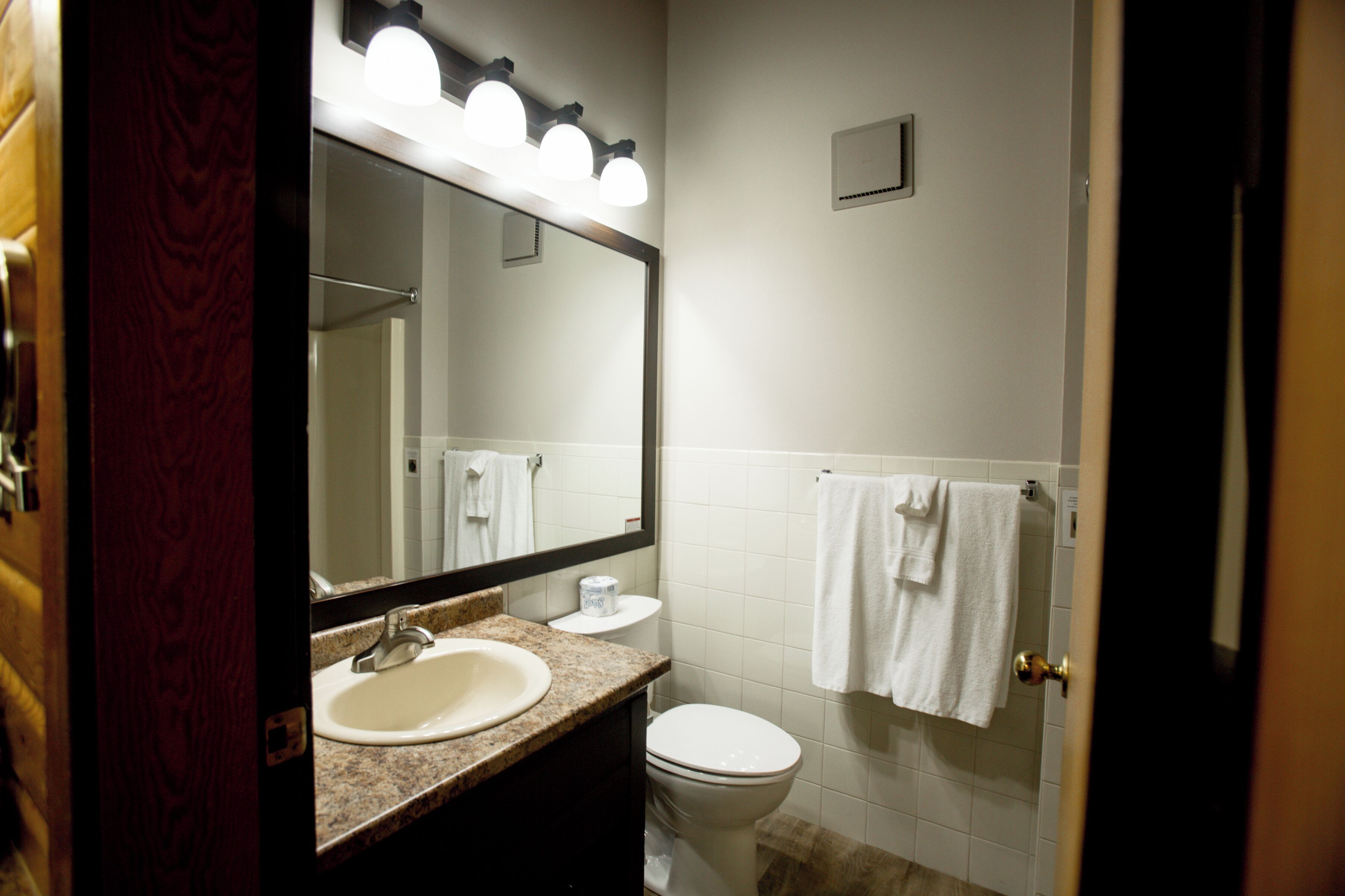 Un bagno con lavandino, specchio e water.