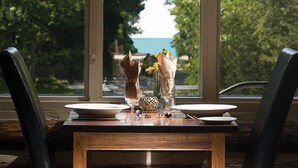 A dining table with two plates, a vase with flowers, and a glass. - Oakwood Resort (South Huron)