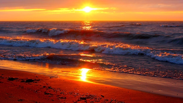 A beach at sunset with waves and a clear sky. - Oakwood Resort (South Huron)