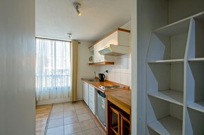 Departamento | Cocina privada | Refrigerador con congelador, parrilla de estufa y utensilios de cocina 