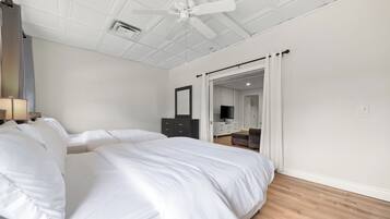 Ein Schlafzimmer mit einem großen Bett, einem Deckenventilator, einem Kleiderschrank und einem Spiegel.