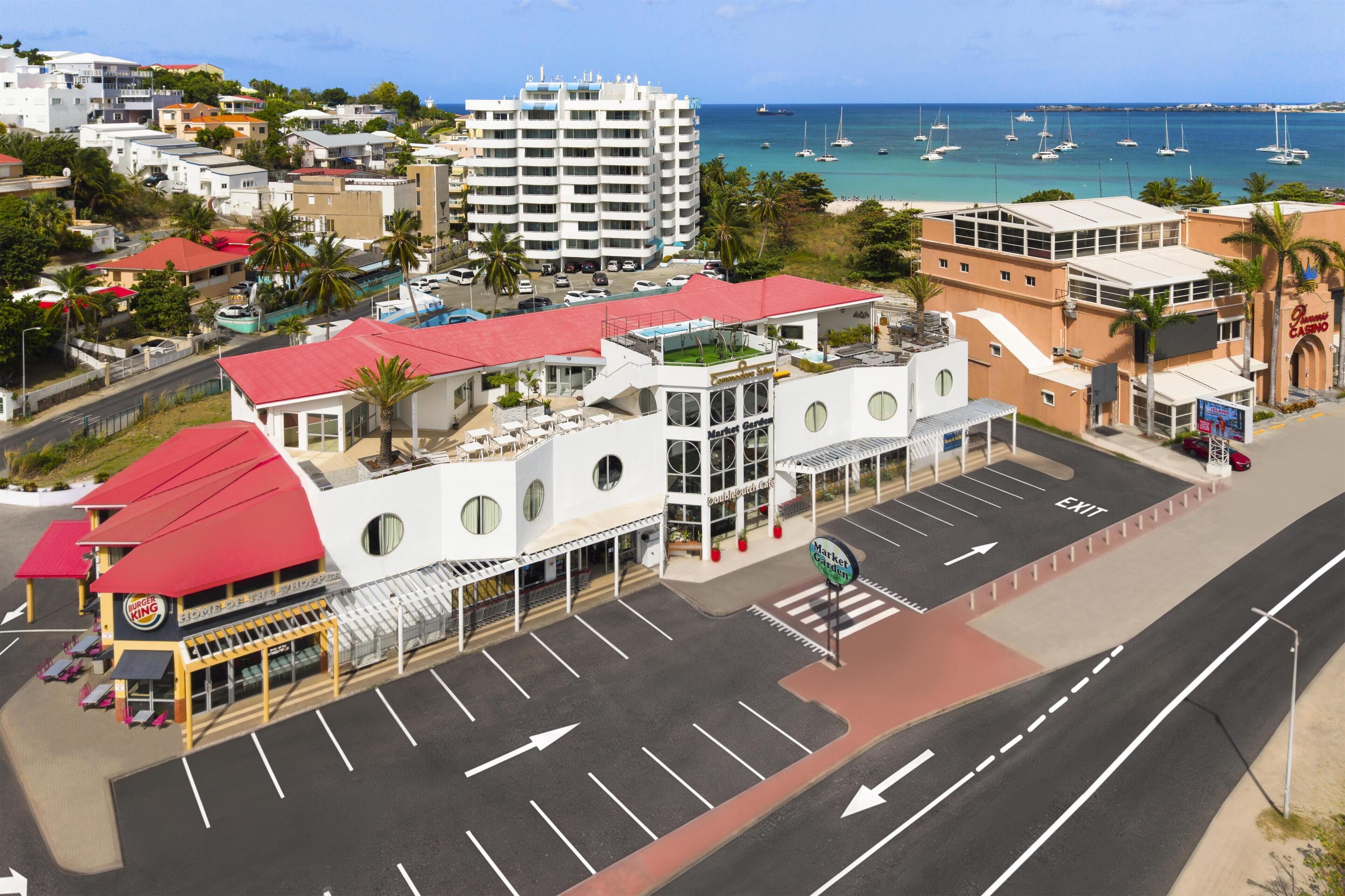 A coastal hotel with a red-roofed building, a market garden, and a casino.