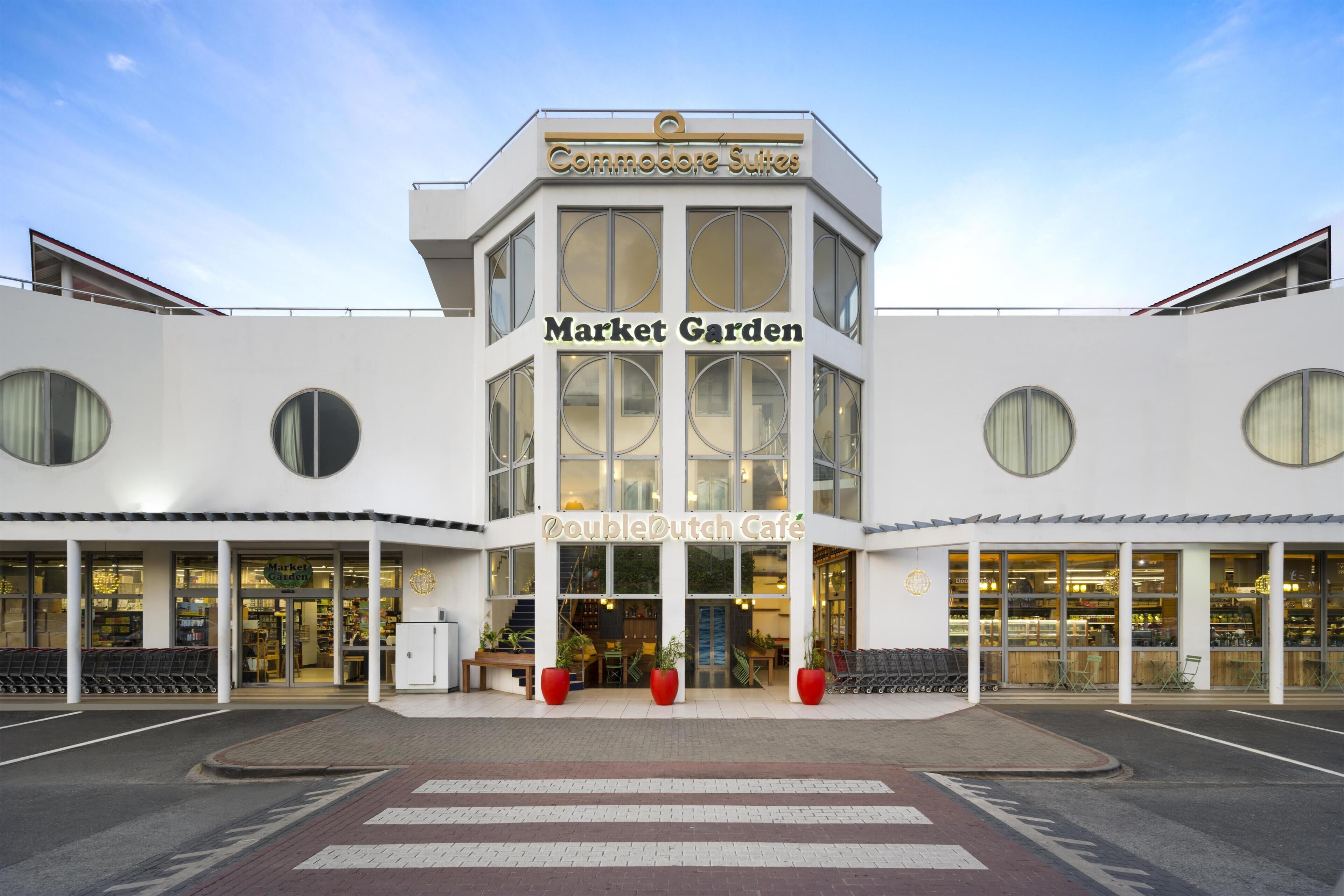 A building with a sign for 'Market Garden' and 'Double Dutch Cafe' on the ground floor.