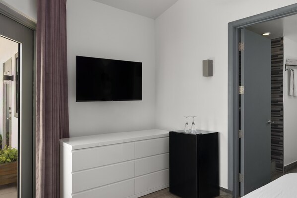 A modern bathroom with a white vanity, a black cabinet, and a mirror.