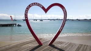 A heart-shaped structure with text, a wooden pier, and boats on water. - Commodore Suites, SureStay Collection by Best Western (Simpson Bay)