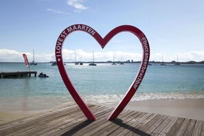 A heart-shaped structure with text, a wooden pier, and boats on water. - Commodore Suites, SureStay Collection by Best Western (Simpson Bay)