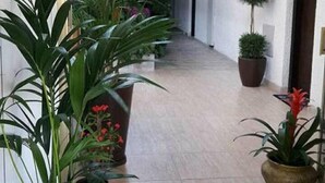 A corridor with potted plants and a welcome sign.