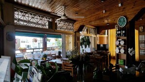 A restaurant with wooden interior, tables, chairs, and a clock on the wall.