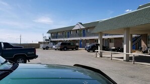 A motel with a covered parking area and a two-story building with a flat roof. - Budget Inn Express Douglas (Douglas)